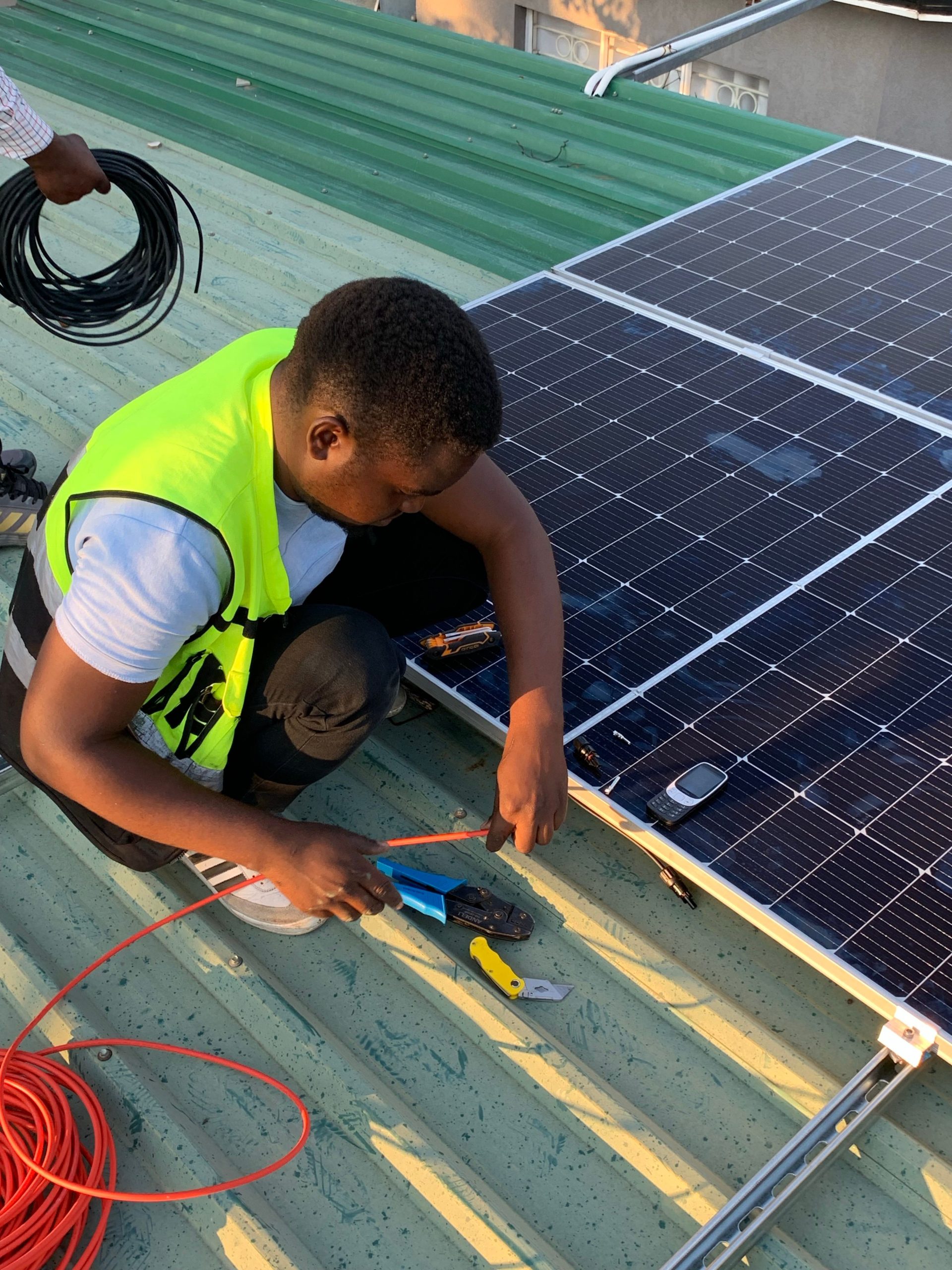 Technicien africain installation panneaux solaires toiture villa Sénégal GDS Construction